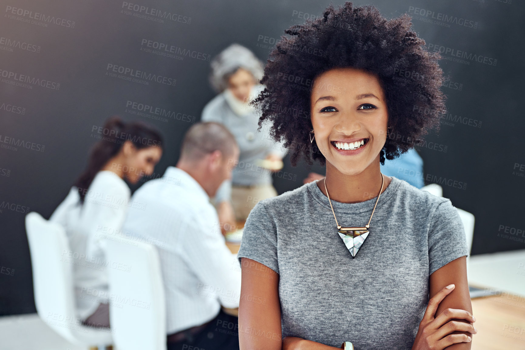 Buy stock photo Portrait of a businesswoman standing with her arms folded in the boardroom while a colleague gives a presentation in the background