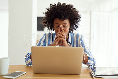 Buy stock photo Cropped shot of a young woman looking stressed out while working on her laptop at home