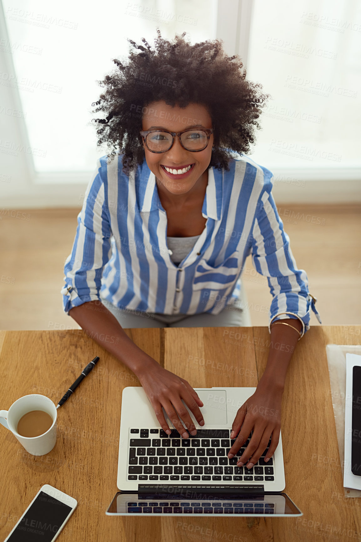 Buy stock photo Portrait, girl and top view with laptop, working and home with coffee, remote work and smile. African woman, typing and glasses for computer, online and happy or freelancer, pc  and employee indoors