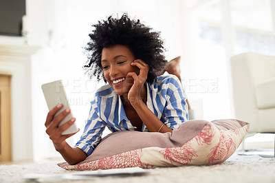 Buy stock photo Black woman, home and smile on smartphone with lying on floor for online application or booking for traveling. Female person, living room and happy with loan approval, results and mobile app