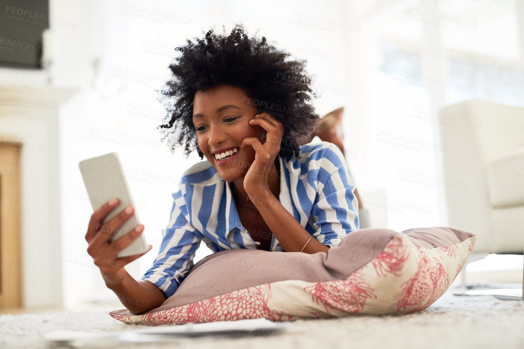 Buy stock photo Black woman, home and smile on smartphone with lying on floor for online application or booking for traveling. Female person, living room and happy with loan approval, results and mobile app