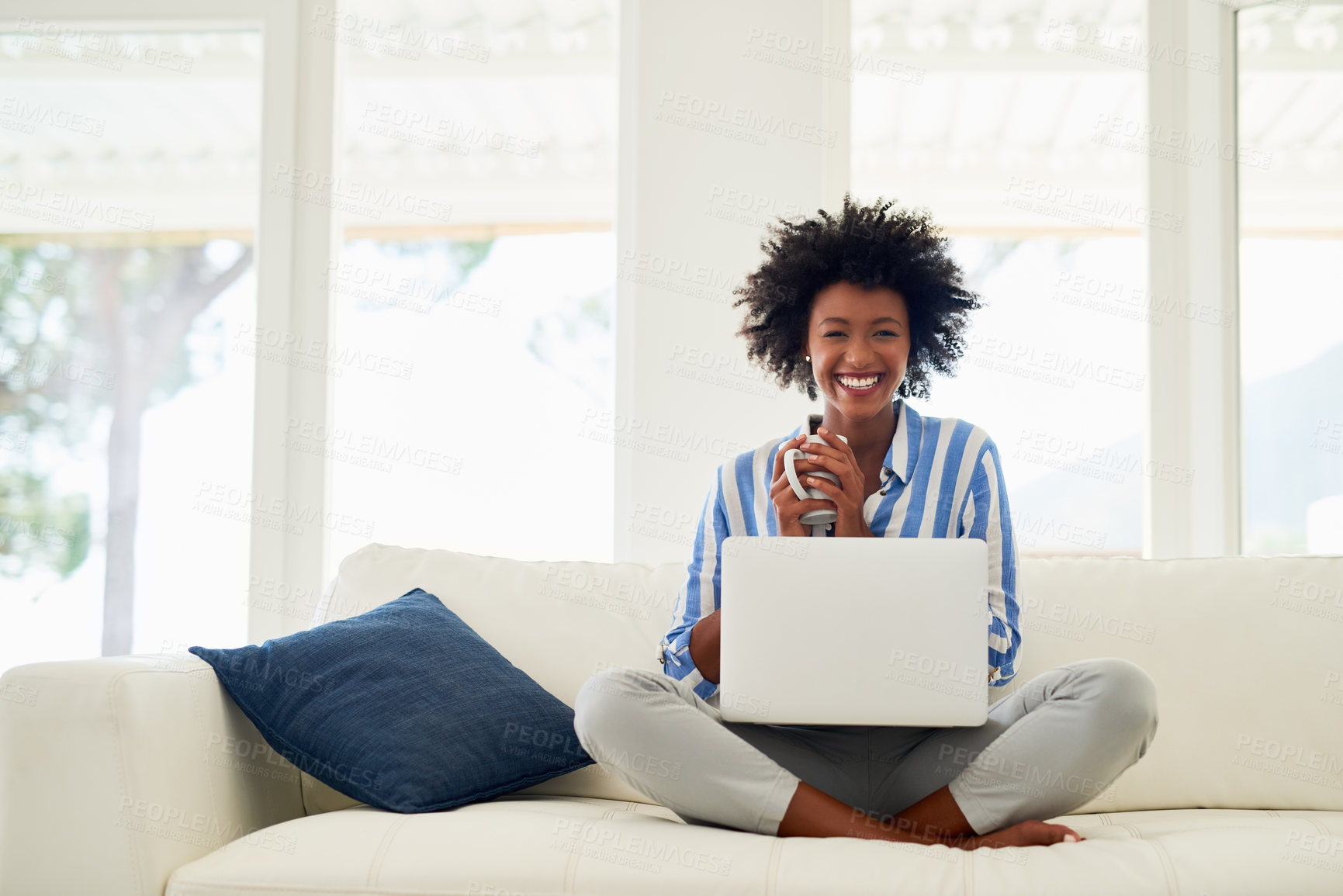 Buy stock photo Portrait of a young woman drinking coffee while working on her laptop at home