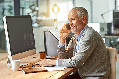 Buy stock photo Shot of a mature businessman talking on the phone while sitting at his desk in an office