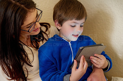 Buy stock photo Cropped shot of a mother and son using a digital tablet at home