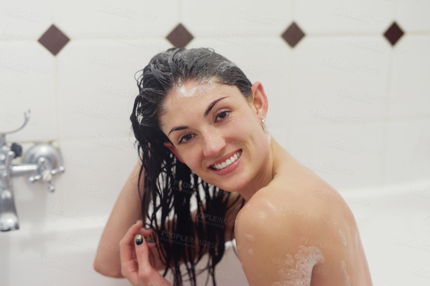 Buy stock photo Portrait of a young woman washing her hair in the bath