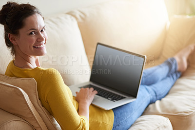 Buy stock photo Shot of an attractive young woman using her laptop on the sofa at home