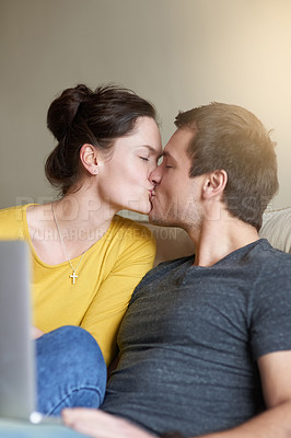 Buy stock photo Couple, kiss and laptop on sofa with love or bonding for romance with streaming videos, comedy shows and online. Man, woman and relax together in home with digital technology for movies and happiness