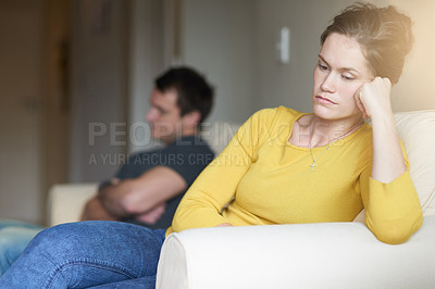 Buy stock photo Cropped shot of an unhappy young couple sitting on the couch at home after a fight