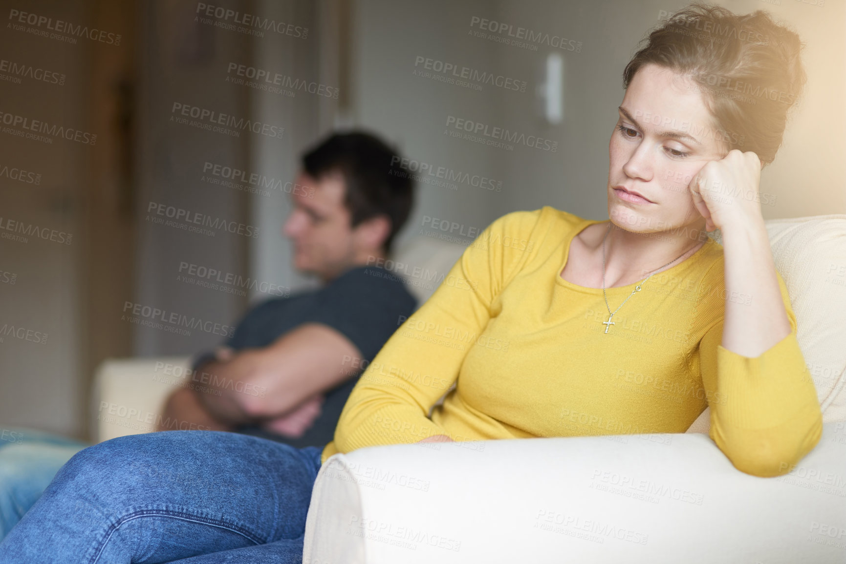 Buy stock photo Cropped shot of an unhappy young couple sitting on the couch at home after a fight