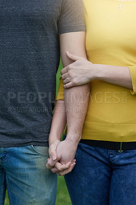 Buy stock photo Shot of an unidentifiable couple holding hands while standing outside together