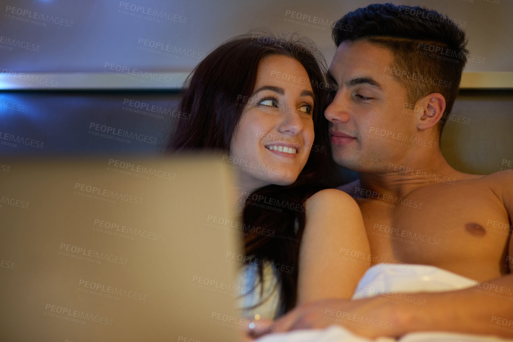 Buy stock photo Happy couple, laptop and relax in bed together for date night, love and intimacy at home. Excited man and woman with technology to stream or watch tv in bedroom on weekend, holiday or summer vacation