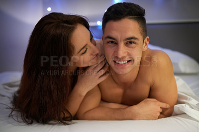 Buy stock photo Portrait of an affectionate young couple lying on their bed together