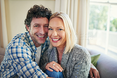 Buy stock photo Cropped portrait of a mature couple sitting on their sofa at home