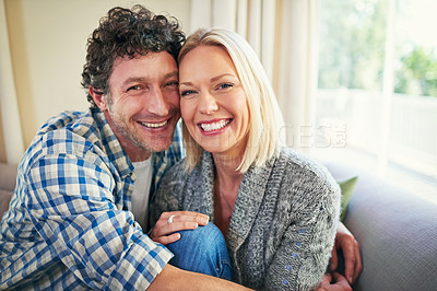Buy stock photo Cropped portrait of a mature couple sitting on their sofa at home