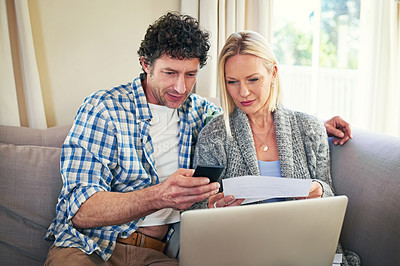 Buy stock photo Shot of a mature couple going over the expenses while sitting on the sofa at home