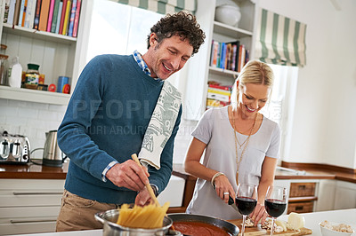 Buy stock photo Couple, stove and cooking pasta or laughing in home, love and care for food or meal in kitchen. Happy people, dinner and pan for sauce and joke for bonding, nutrition and wine glasses for marriage