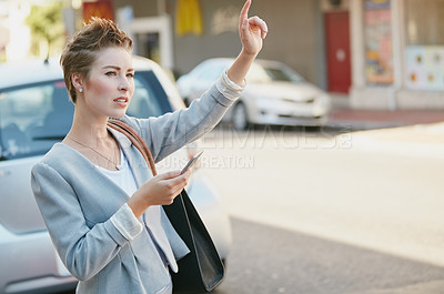 Buy stock photo Cropped shot of a young businesswoman gesturing to get a cab in the city