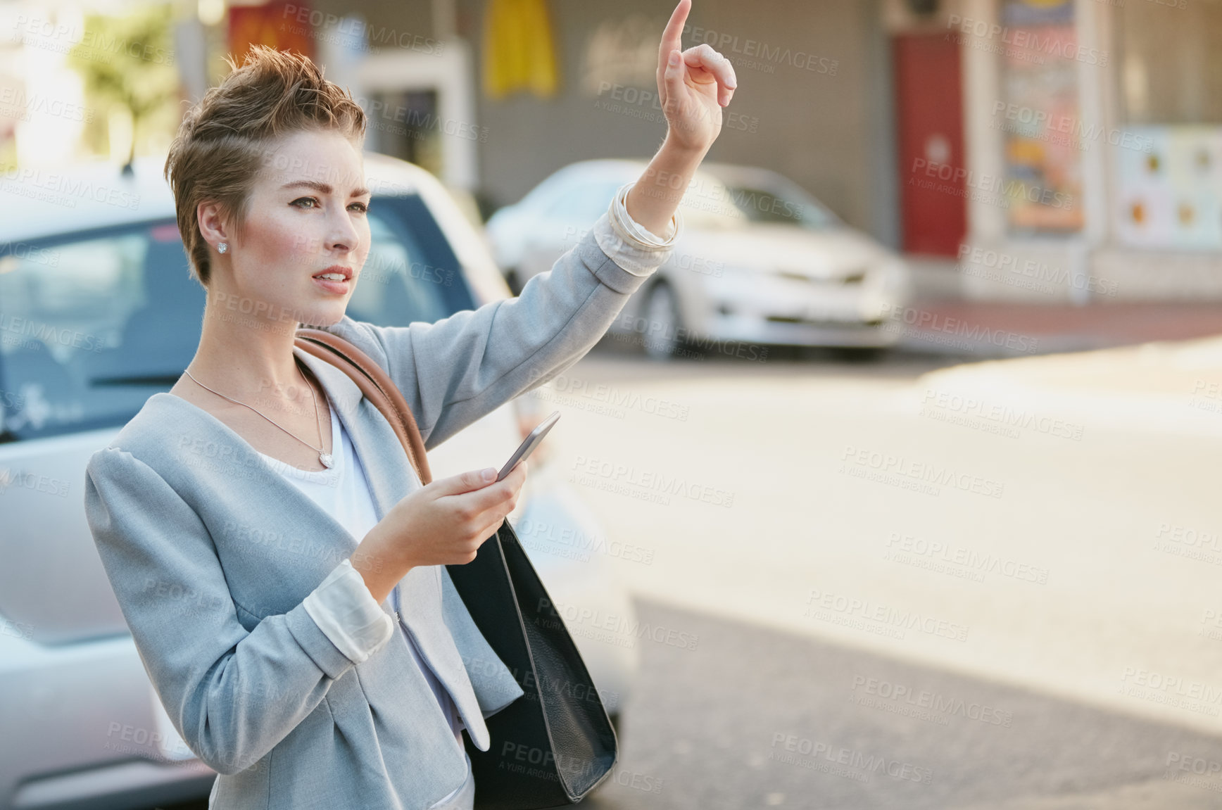 Buy stock photo Cropped shot of a young businesswoman gesturing to get a cab in the city