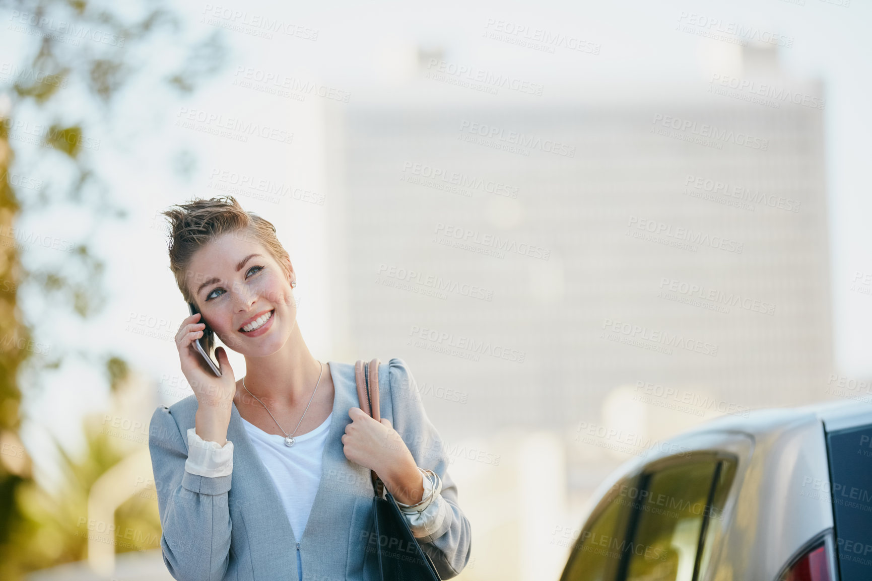 Buy stock photo Cropped shot of a young businesswoman talking on her cellphone while out in the city