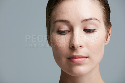 Buy stock photo Studio shot of an attractive young woman posing against a gray background