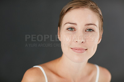 Buy stock photo Studio portrait of an attractive young woman posing against a gray background