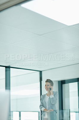 Buy stock photo Cropped shot of a young businesswoman talking on a cellphone in an office