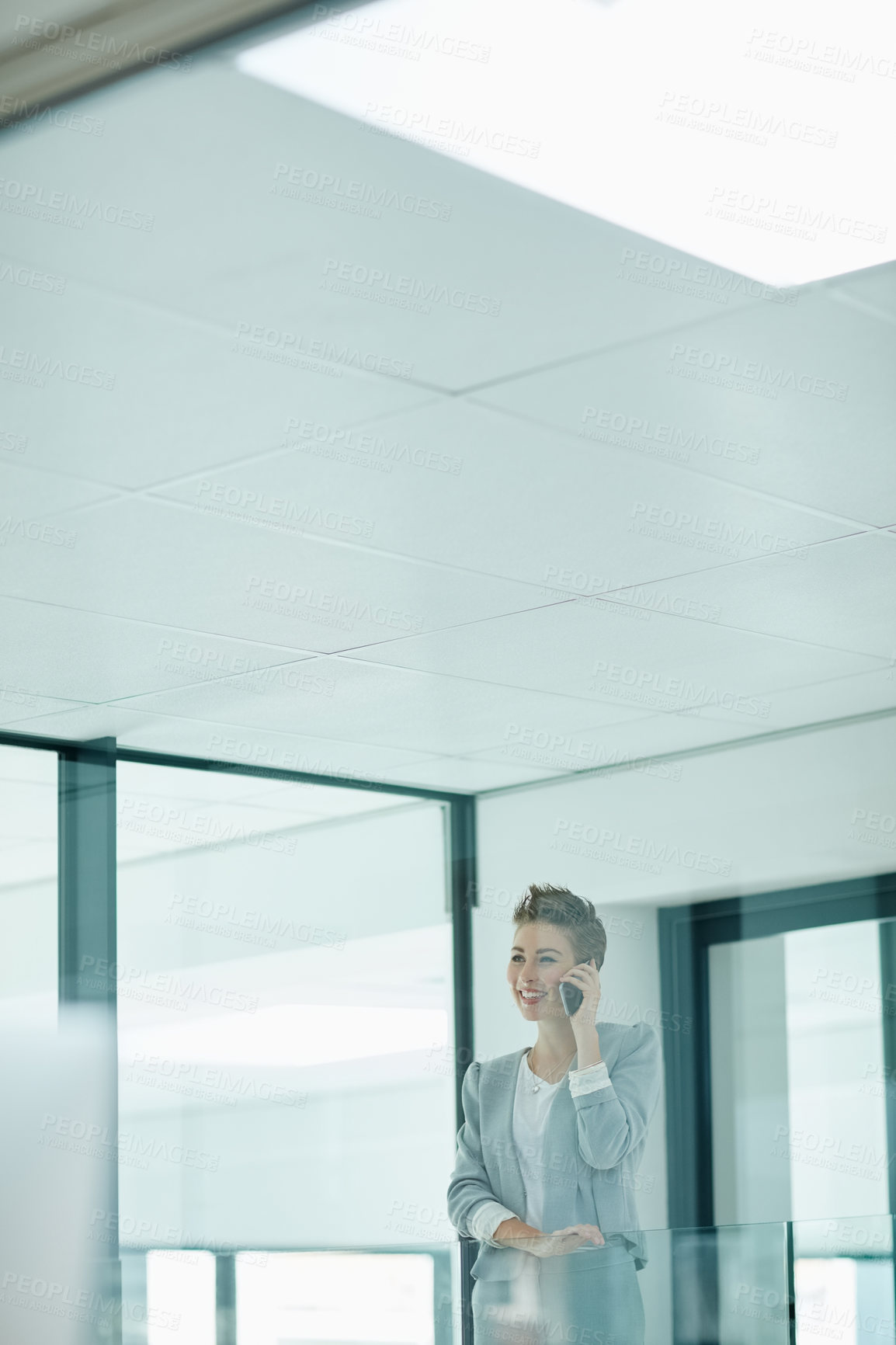 Buy stock photo Cropped shot of a young businesswoman talking on a cellphone in an office