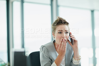 Buy stock photo Cropped shot of a young businesswoman looking shocked while talking on a cellphone in an office