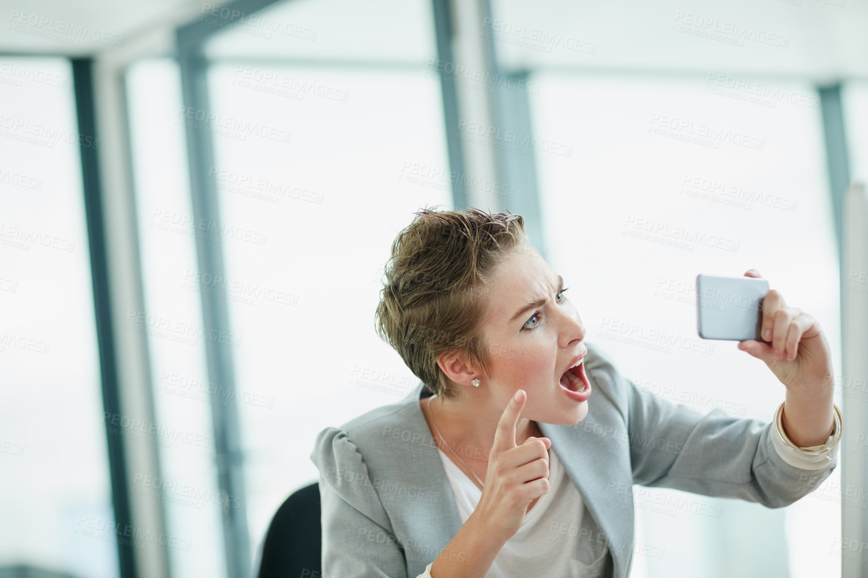 Buy stock photo Cropped shot of a young businesswoman making a face while taking a selfie with her cellphone