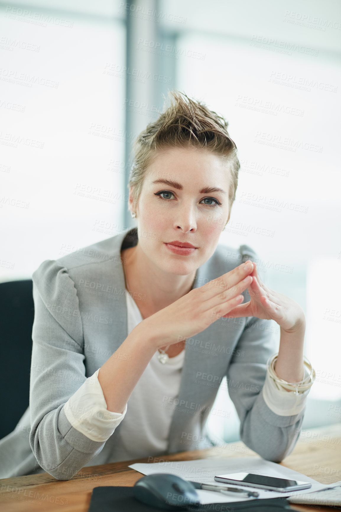 Buy stock photo Portrait of a young businesswoman sitting at a desk in an office