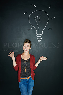 Buy stock photo Studio shot of a young woman posing with a chalk illustration of a lightbulb against a dark background