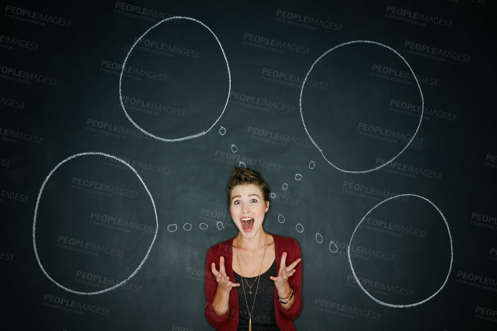 Buy stock photo Studio shot of a young woman posing with a chalk illustration of thought bubbles against a dark background