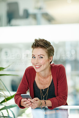 Buy stock photo Portrait of an attractive young businesswoman using her cellphone in the office