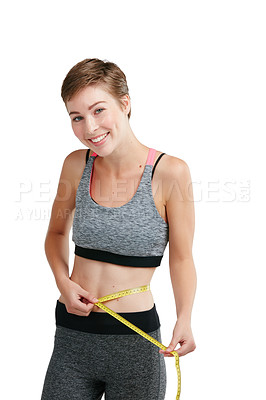 Buy stock photo Studio portrait of a fit young woman measuring her waist against a white background