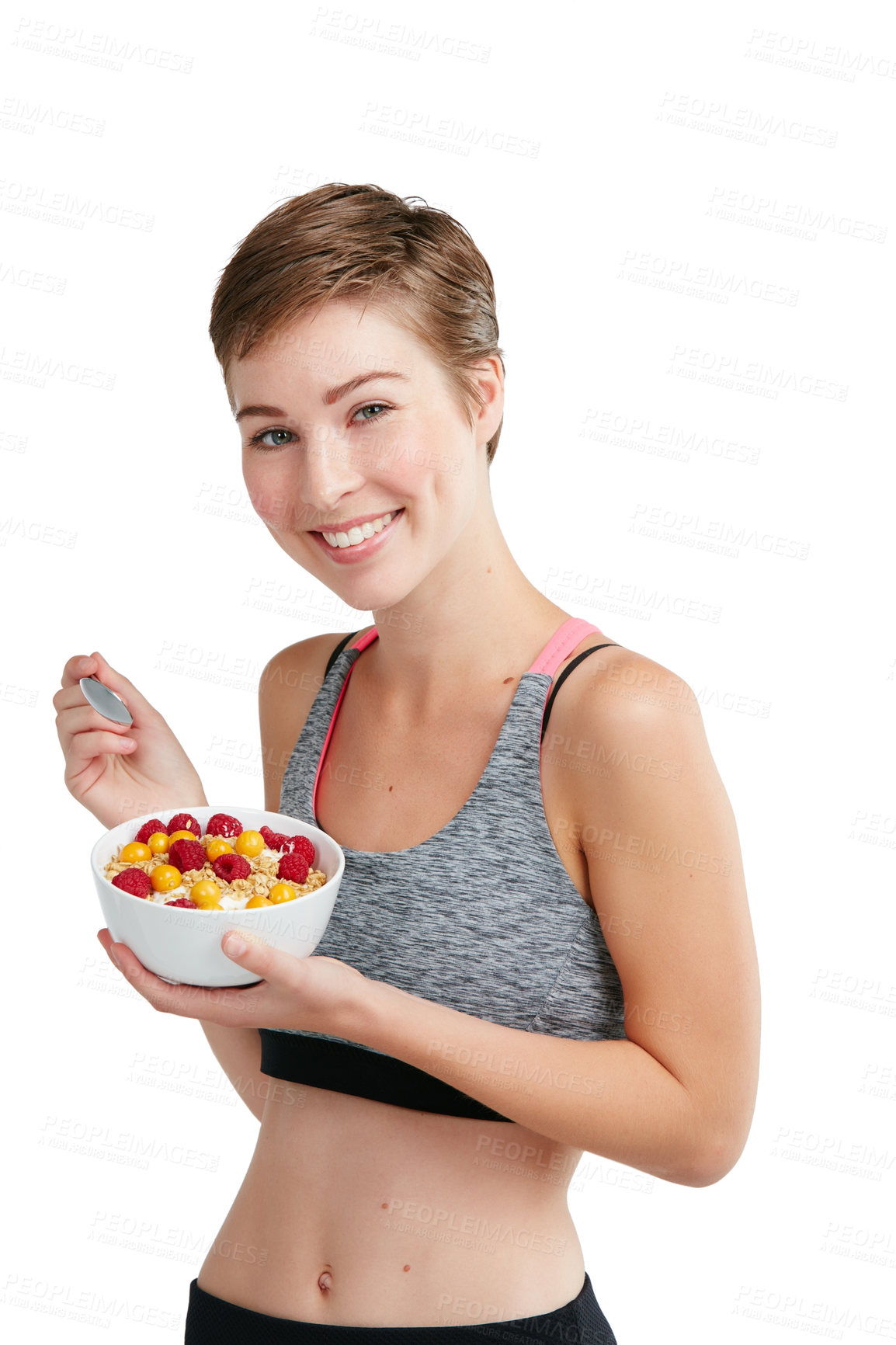 Buy stock photo Studio portrait of a fit young woman eating a bowl of fruit and granola against a white background