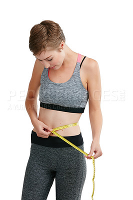 Buy stock photo Studio shot of a fit young woman measuring her waist against a white background