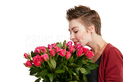 Buy stock photo Studio shot of a young woman smelling a bouquet of flowers against a white background