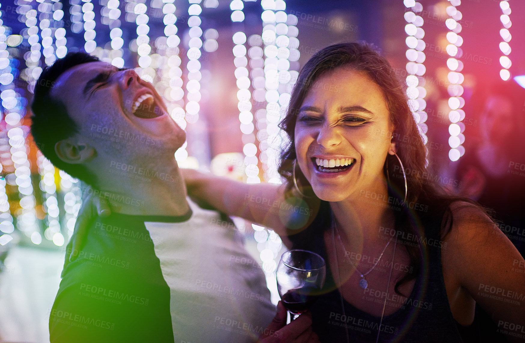 Buy stock photo Laugh, lights and couple in nightclub for fun, music or happy weekend drinks at social event. Nightlife, man and woman on date at dance club with wine, smile and celebration together in party culture