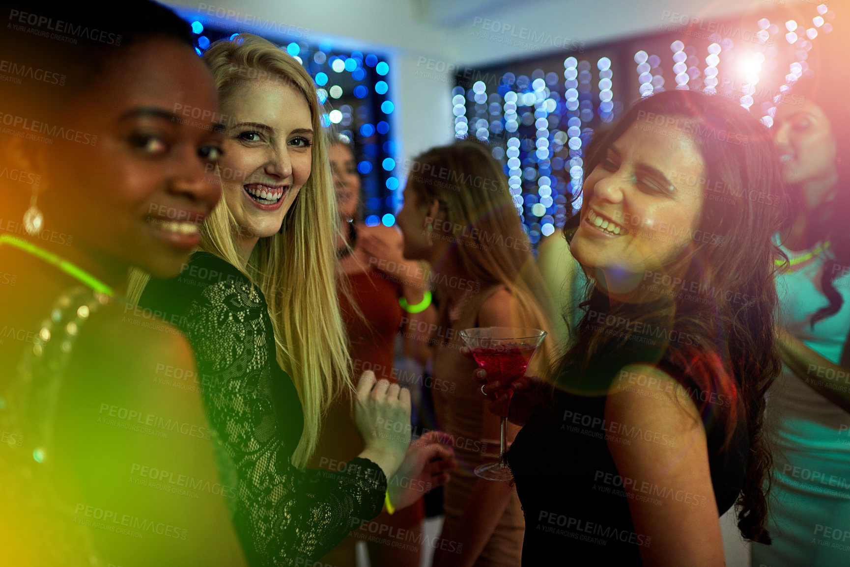 Buy stock photo Shot of a group of young people enjoying themselves at a nightclub