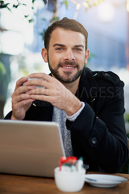 Buy stock photo Shot of a handsome young man enjoying a coffee break at an outdoor cafe