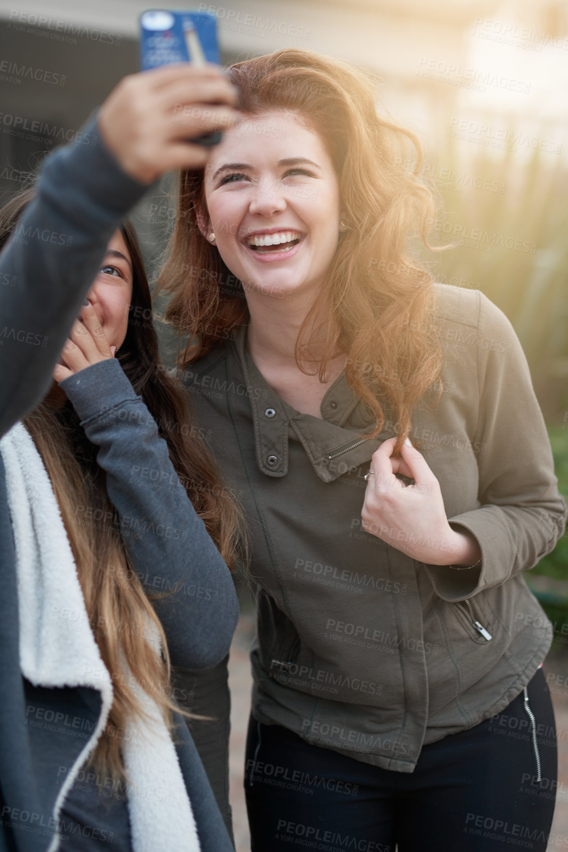 Buy stock photo Shot of two young women taking a selfie outdoors