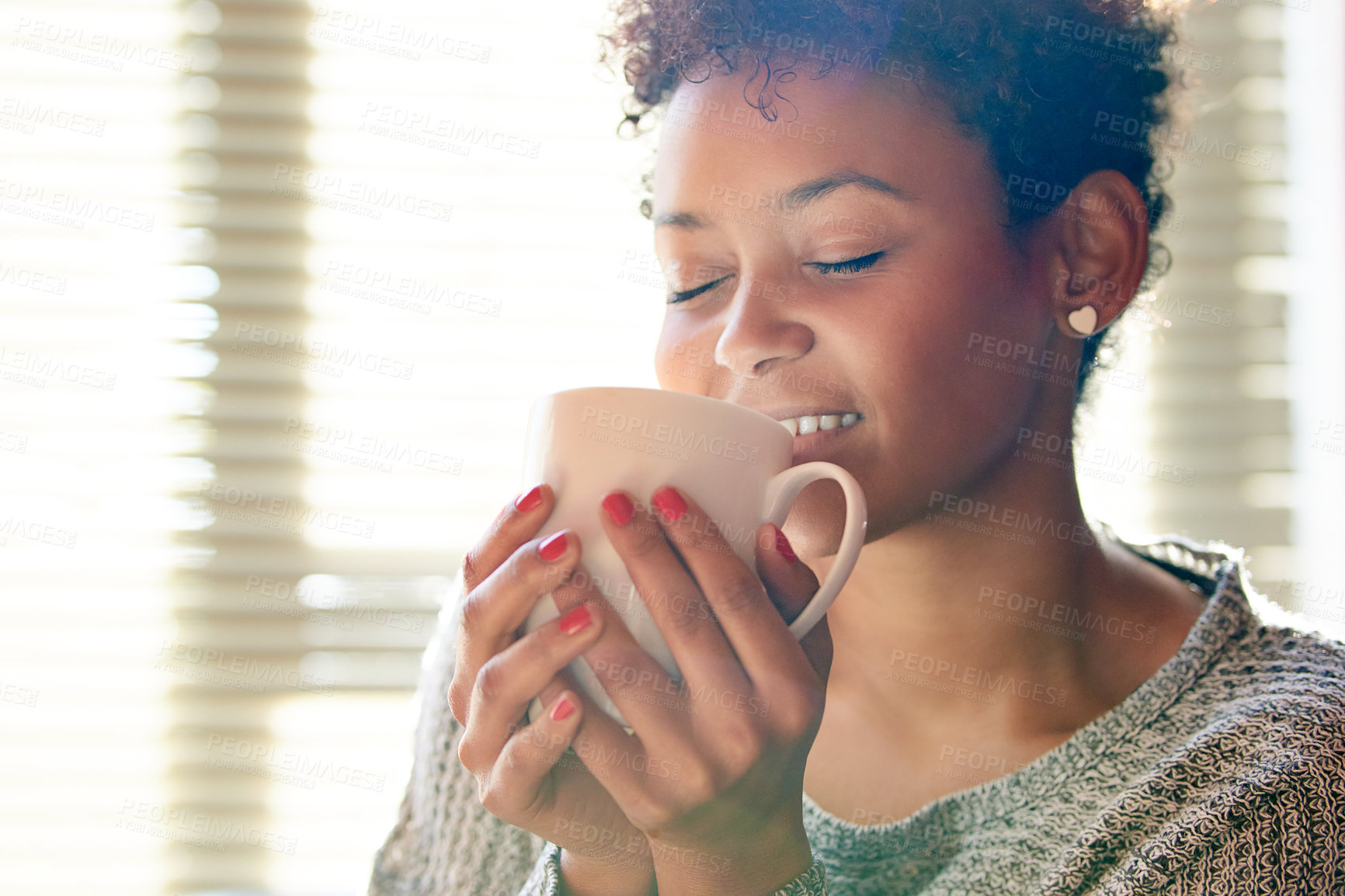 Buy stock photo Cropped shot of a young woman relaxing at home with a cup of coffee