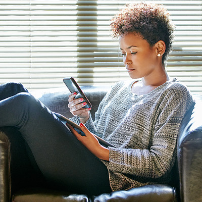 Buy stock photo Cropped shot of a young woman using a cellphone and digital tablet at home