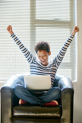 Buy stock photo Shot of a young woman looking at her laptop with her arms raised in celebration