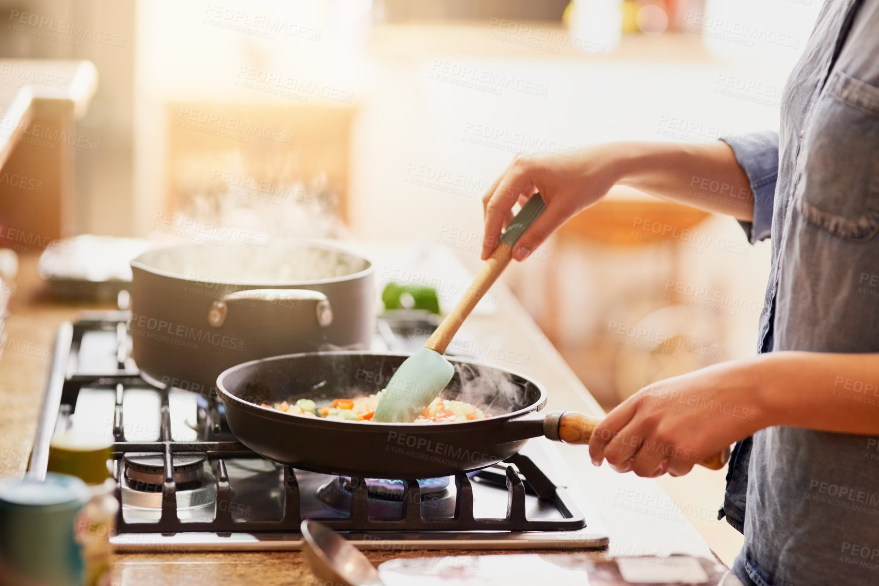 Buy stock photo Cropped shot of a young woman preparing a meal at home