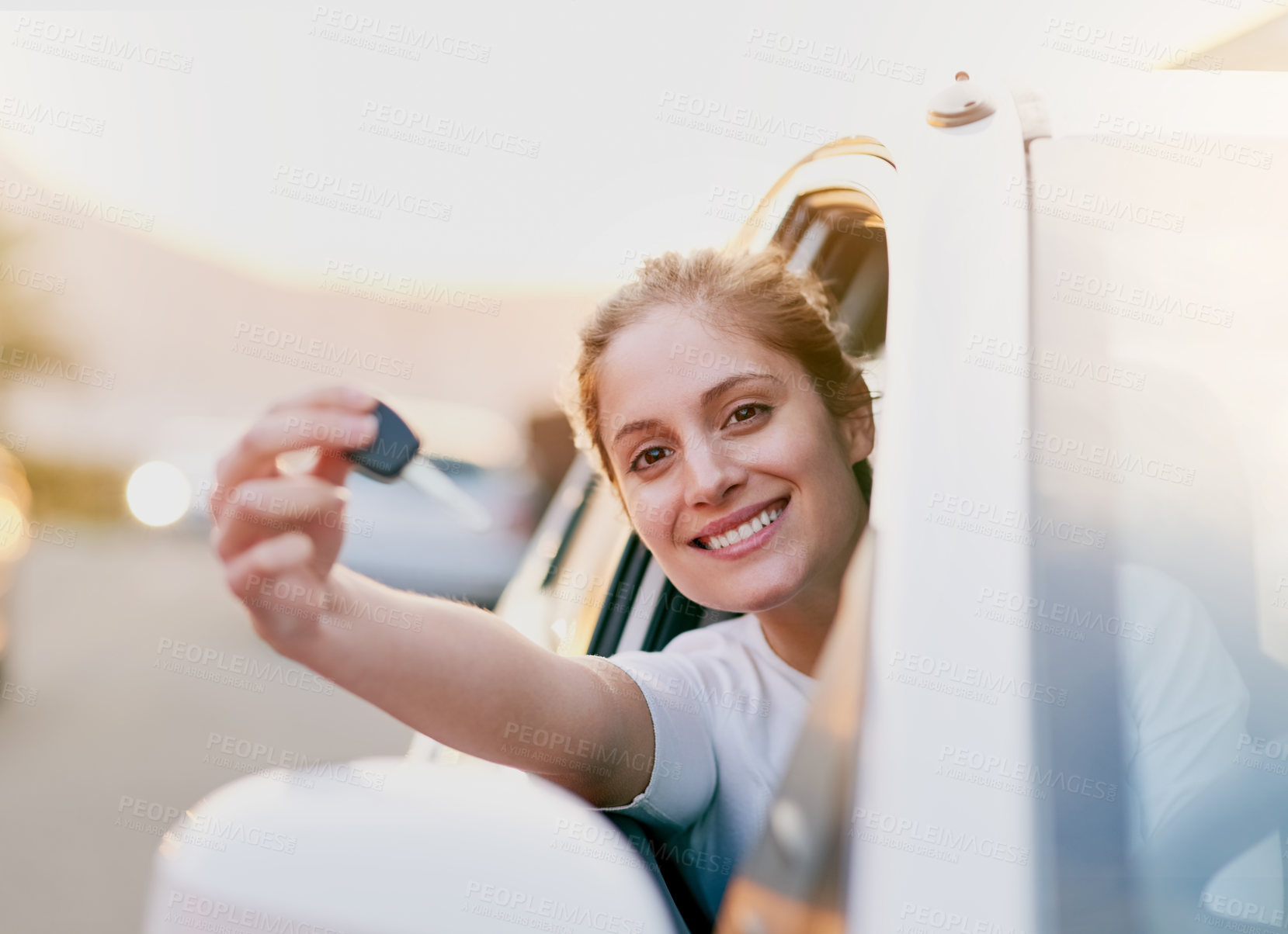Buy stock photo Portrait of a young woman holding the keys to her car while sitting inside it