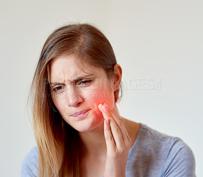 Buy stock photo Cropped shot of a young woman experiencing a toothache highlighted in glowing red