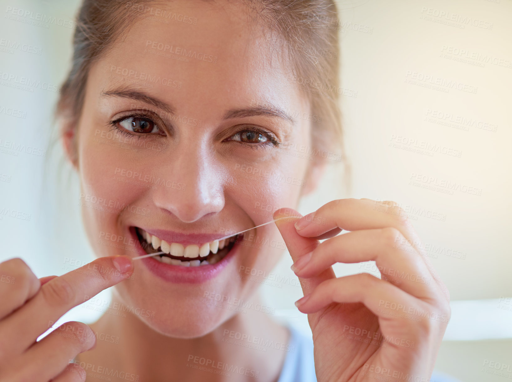 Buy stock photo Portrait of a young woman flossing her teeth in a bathroom