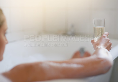 Buy stock photo Cropped shot of a young woman relaxing in the bathtub with a glass of wine
