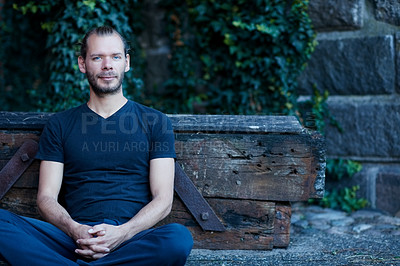Buy stock photo Portrait of a man sitting against a wall outside
